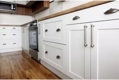 freshly painted white kitchen cabinet with silver handles and knobs